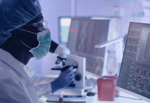 Scientist working in a lab, looking at a computer screen